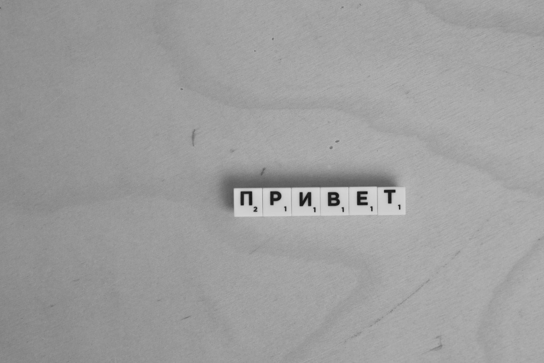 Kafelki Scrabble układające się w rosyjski napis Privet na drewnianym blacie