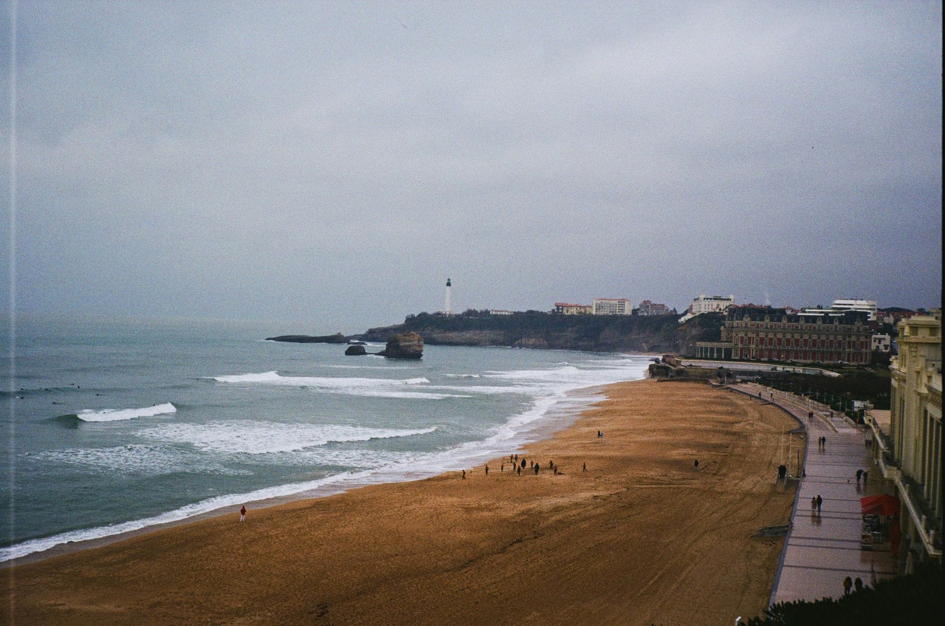 Latarnia morska i zabudowa Biarritz nad Atlantykiem, fale uderzają o brzeg