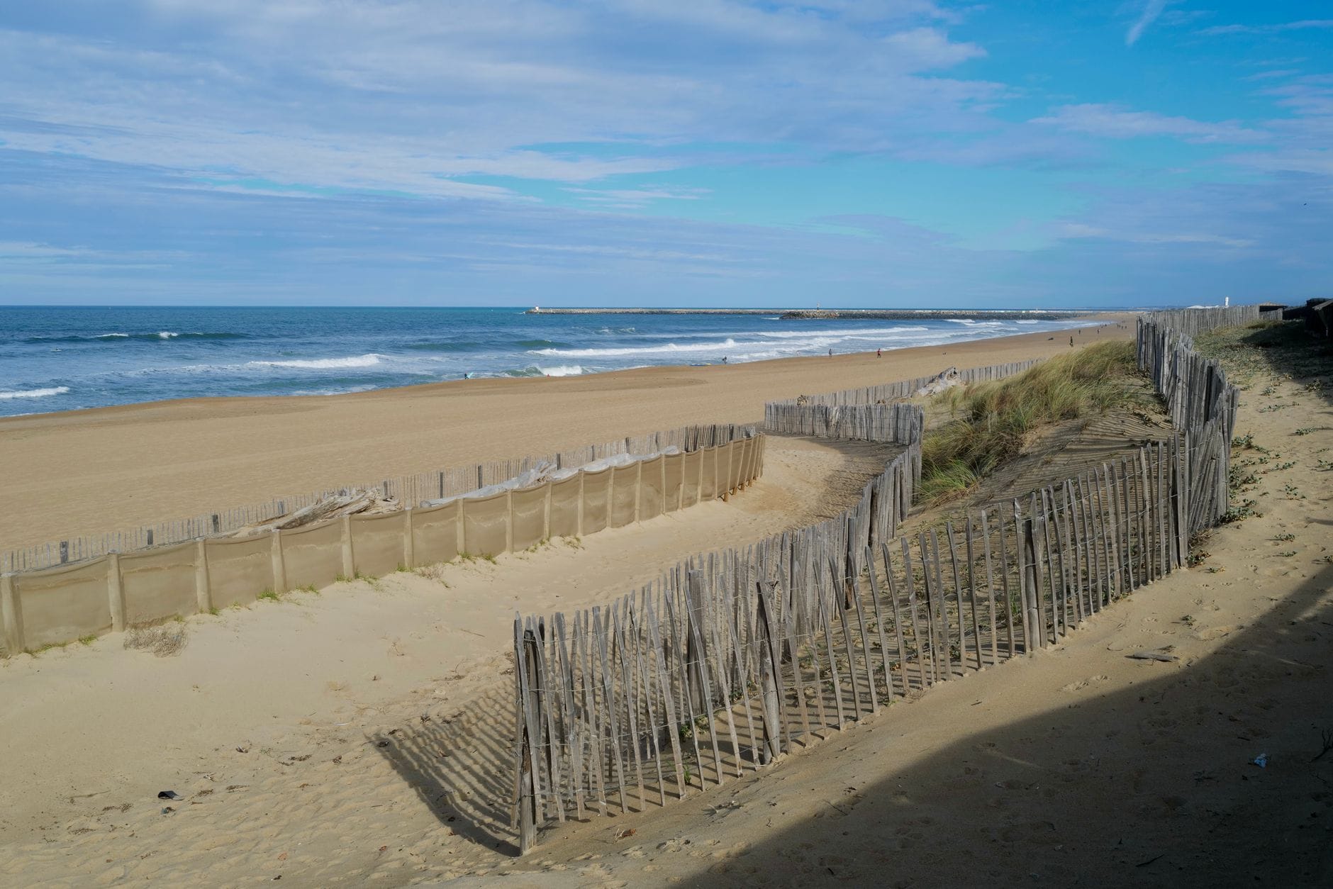 Piaszczyste wydmy i spokojne fale oceanu na plaży Anglet we Francji