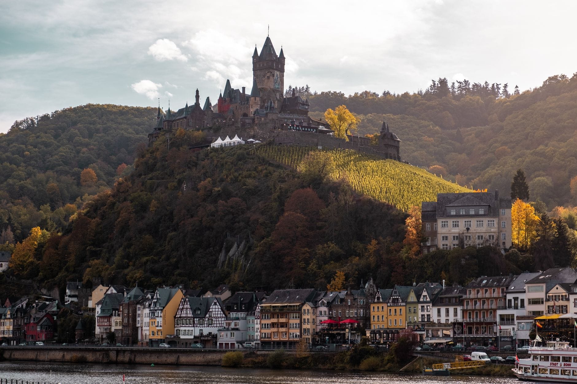 Zamek Cochem na wzgórzu nad miasteczkiem w jesiennych barwach